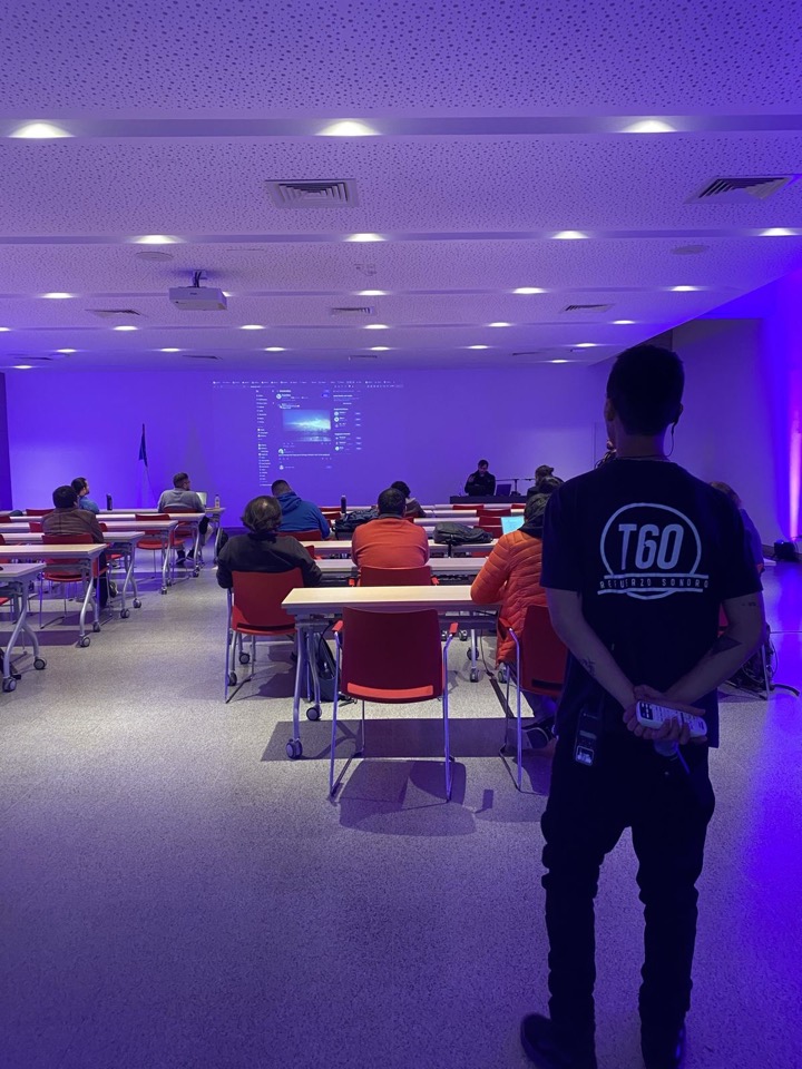 Integrante de T60 supervisando una sala de capacitación con proyección e iluminación de ambiente